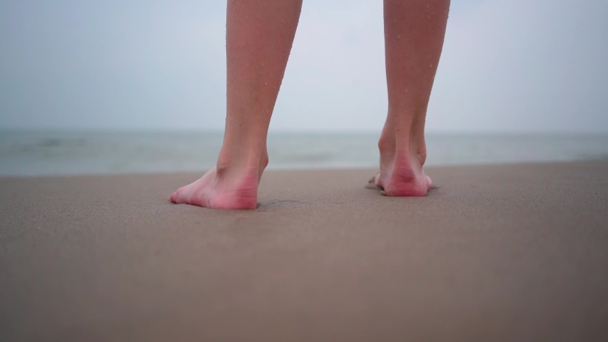 Close up of person bare feet walking at tropical beach. People playing barefoot at tropical beach. Having fun jumping in sea water on warm sunny day on seashore. Summer travel and vacation concept. | Shutterstock HD Video #1090530597