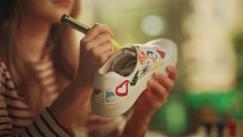 Focused Female Designer Drawing on Shoes while Working with Inspiration in Modern Loft Place. Modern Artist Creating Design of Sneakers. Modern Freelancer at Remote Work Concept. Slow Motion