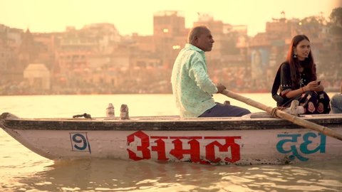 A view of the holy ghats of Varanasi with a boatman sailing: November 18 2021 - Varanasi, Uttar Pradesh, India