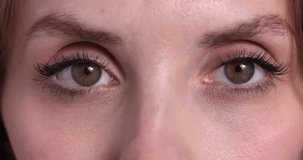 Blink. Closeup female brown color eyes. Young beautiful girl closing and opening eyes, looking at camera and away. Concept of beauty, diversity, youth, art. Slow-motion, macro extreme close-up, 4K.