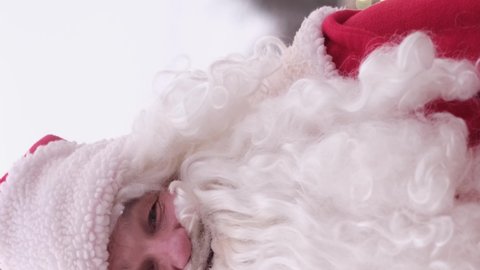 Vertical video, Santa Claus showing thumb up, class gesture sign, looking at camera