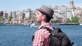 Young man tourist in red shirt hat and backpack looking at beautiful touristic places sightseeng of Istanbul