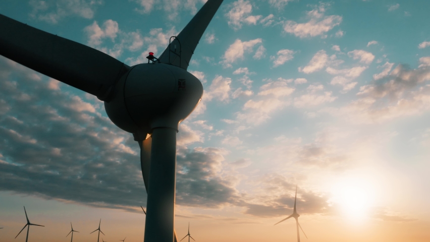 Wind turbines at sunrise aerial view. Wind farm generating green energy, producing electricity Royalty-Free Stock Footage #1090546559