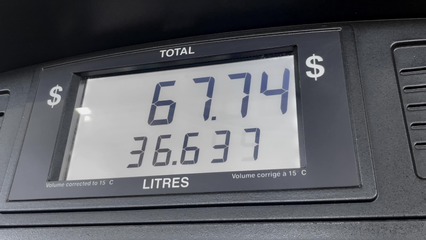 Gas price screen in dollars on fuel pump increasing based on litres, close up