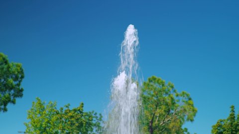 
Fountain in the park, summer sunny day, green trees and blue sky.