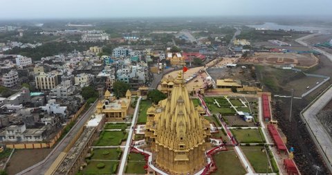 somnath , Gujarat , India - 05 20 2022: Aerial rotating drone shot of Somnath temple and city. Temple of Lord Shiva in Somnath, Gujarat, one of most famous Jyotirlinga of India.