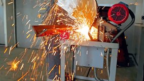 Worker in production hall cuts metal with circular saw and sparks fly. work with metal. slow motion video.