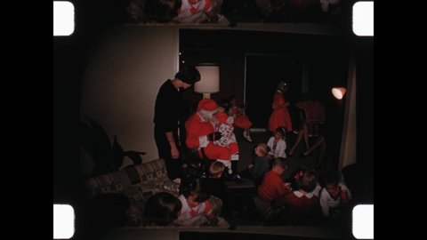1968 Miami Beach, FL. Santa Clause sits in a rocking chair, Mother and auntie help distribute gifts to anxious children on Christmas Eve. 4K Overscan of Vintage Archival 16mm Home Movie Film Print