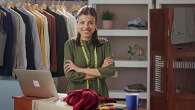 A modern Indian Asian woman or female working professional fashion designer is standing at the studio or workplace with a laptop in front is looking at camera. women empowerment, job equality concept - Powered by Shutterstock - Get 15% off with code: PIKWIZARD15
