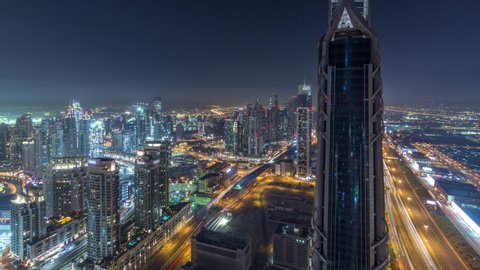Dubai Downtown skyscrapers night timelapse modern towers panoramic view from the top in Dubai, United Arab Emirates. Traffic on the Sheikh Zayed road near business bay