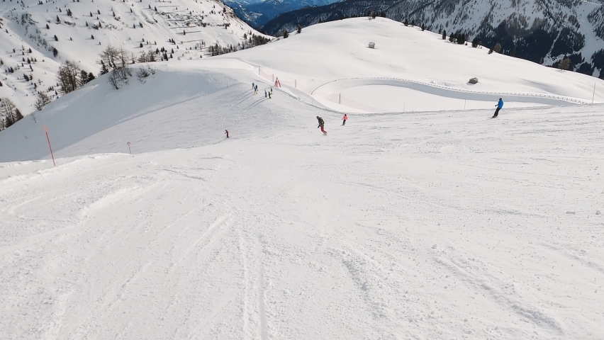 First-person view FPV first-person point of view POV of alpine skiing in Dolomites. Ski resort piste with people skiing in Dolomites in Italy. Ski area Belvedere. Canazei, Italy | Shutterstock HD Video #1090567707