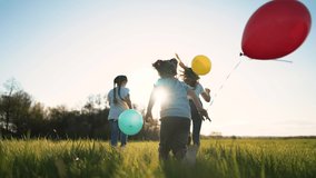 Happy family with balloons run through park. Silhouette of children at sunset in backyard. Group of children are playing on green grass in garden. Child birthday. People running with colored balloons - Powered by Shutterstock - Get 15% off with code: PIKWIZARD15