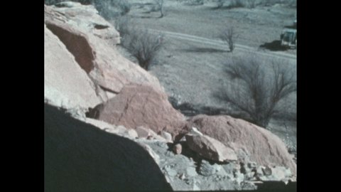 1980s: Juvenile cougar climbs a cliff with two girls chasing after. Mother cougar greets juvenile. Walls of a canyon. Three cougars travel over a ridge in the snow. Clouds pass over a mesa.
