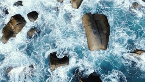Wave sea rock turquoise rolling slow crash rocks coastline sunset. Top view Strong winds cause strong sea waves texture breaking stones during monsoon season United States. Video 4k copy space 2022.
