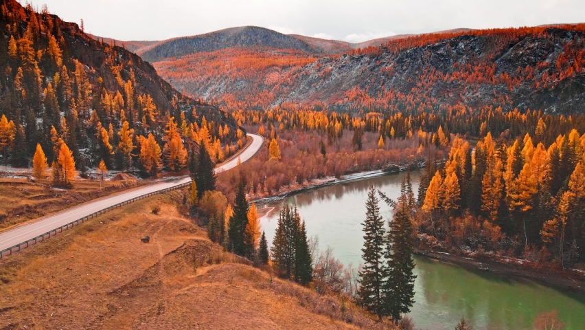 Chuya river in Altai mountains, Siberia, Russia. Aerial drone view. Blue river with yellow autumn trees in the mountains at sunset. Beautiful autumn landscape.
