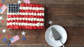 Cake with the colors of the US flag on a wooden background. Independence Day Celebration July 4th. Hand cutting cake and serving on a plate.