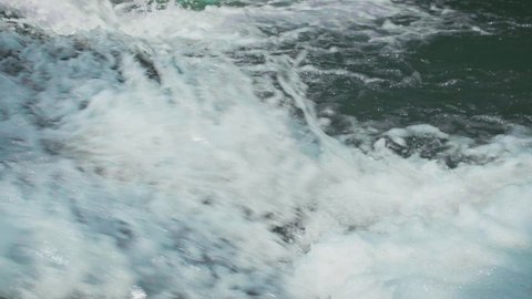 Close up of beautiful turquoise color water splashes in a slow motion. Small waterfall. Horizontal video.