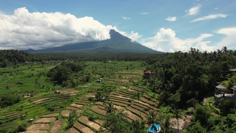 Aerial shot of Bali Volcano, Drone Shot, flying forwards, over rice fields and terraces. Cloudy sky