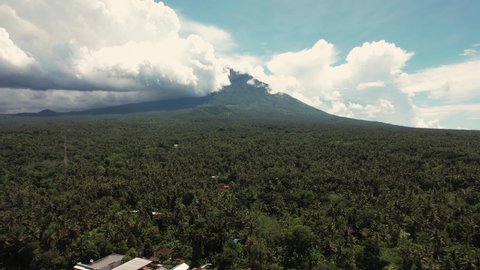 Aerial shot of Bali Volcano, Drone Shot, flying backwards over rice fields and terraces. Cloudy sky
