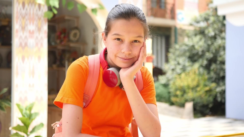Portrait of a smiling teenage girl with red headphones