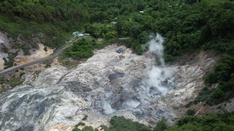 Aerial footage over active Sulphur Springs in Saint Lucia. Rising steam from Soufriere's fumaroles, in the world's only drive-in volcano.