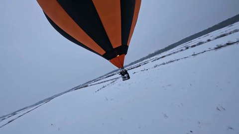 FPV Drone Shot of Hot Air Balloon Basket, Burner and Parachute Above Snow Capped Land