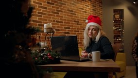 Woman working on laptop in christmas at home indoors. Child girl disturb attractive young adult caucasian female sitting looking at notebook screen inside. Self employed person at work on holidays