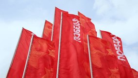 Group of red flags with Russian Pobeda word (means Victory) swings on flagpoles. Clouds on the sky in the background. 4K resolution real time video. Russian Victory day holiday theme.