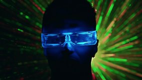 The close up view on a man in futuristic glasses on a color rays background