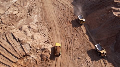 Mining truck transportation sand in open-pit mine, drone view. Sand transport from open pit. Haul truck in sand quarry. Lorry in opencast. Mining industry concept. Bulk construction supplies.