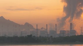 Time lapse video 4K motion, Beautiful in the morning. Thailand, Mae Moh coal power plant and lake. The pipe cooling tower emits an industrial white steam, creating a conceptual environ	