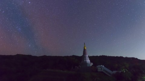 Time Lapse 4K of The Milky Way Galaxy moving over a sacred temple at Doi Inthanon National Park, Chiang Mai, Thailand. Night lapse from night to day. Starry night.	