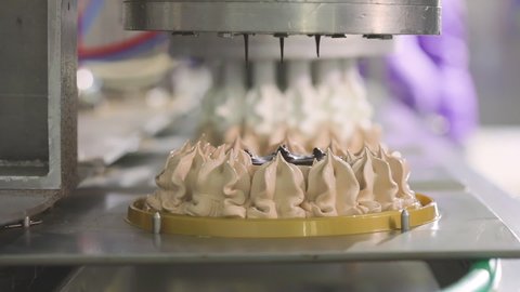 Automated production of ice cream. Automated conveyor for creating an ice cream cake. Ice cream nicely squeezed out of the tubes