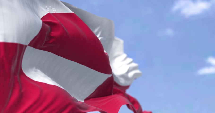 Seamless loop in slow motion of the flag of Greenland waving in the wind on a clear day. Greenland is the world