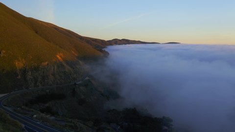 Drone Shots of Pacific Coast Cliffs near Big Sur and Carmel Highlands California during Marine Fog Layer and Sunset. Beautiful 4K Drone footage of Highway 1 Fog. 