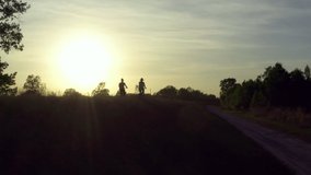 Two women ride bicycles in the park. Beautiful nature aerial view of a girl on a walk, lifestyle video.