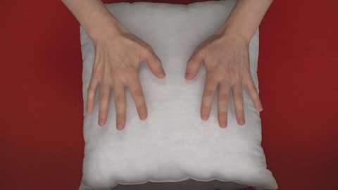 a man slaps on a white pillow