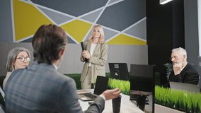 Successful speech. Group of mature colleagues applauding to lady speaker with notepad, enjoying her presentation during corporate meeting, zoom out shot - Powered by Shutterstock - Get 15% off with code: PIKWIZARD15