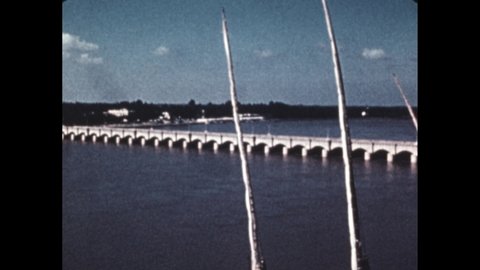 1960s: stone bridge across the Nile, boats docked on bank of the Nile, animation showing how dam lowers water levels to let water flow down tributaries, pyramids raised over distance of the Nile