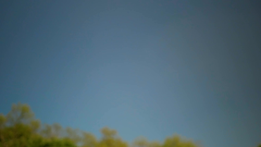 Caucasian male hand with closed fist rising in the air on beautiful sky background. Closeup of strong male fist entering frame from below. White man
