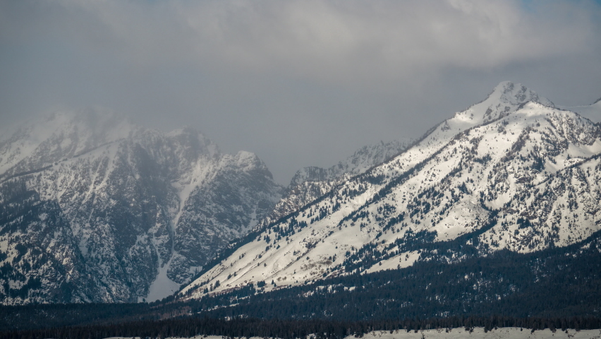 Time Lapse, Mountain Range and Snow Capped Peaks Under Clouds at Early Winter. Grand Tetons, Wyoming USA