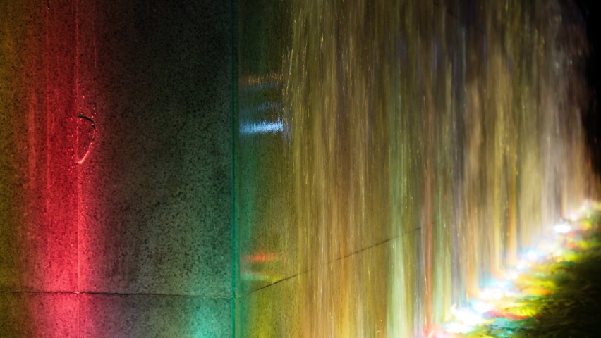 Colorful water fountain during night in the city. Multicolored background. Selective focus