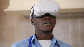 Close-up front view carefree African American man in VR headset gaming online standing in kitchen. Portrait of happy relaxed young guy enjoying virtual reality at home having break cooking - Powered by Shutterstock - Get 15% off with code: PIKWIZARD15