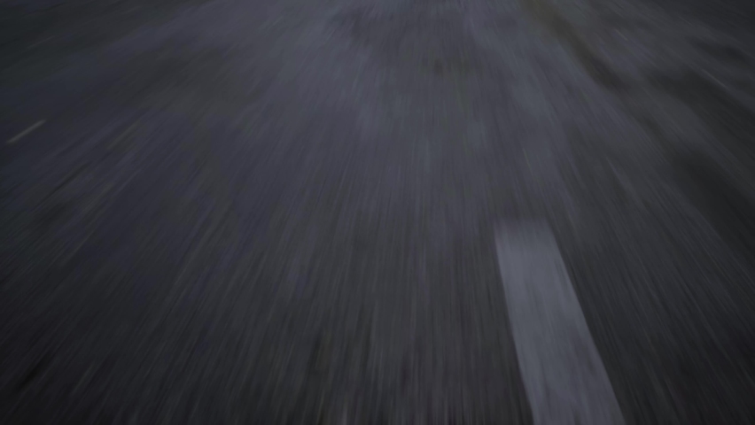 close-up cinematic POV shot of an wet asphalt road. Car or motorcycle is driving on the highway  Royalty-Free Stock Footage #1090618313