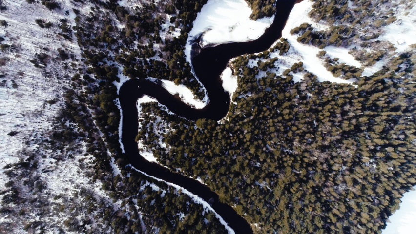 4K Video Sequence of Algonquin Provincial Park, Canada - Bird s-eye view above a river and a forest during the winter