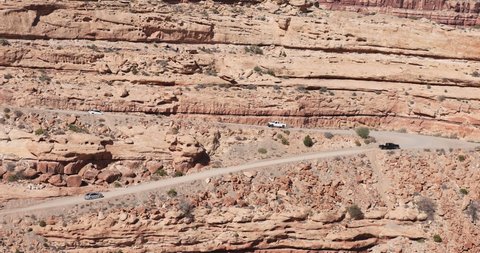Moki Dugway vehicle traffic on steep road southern Utah desert. Roadway carved from a mountain cliff. Scenic cliff Backway of Highway 261 and very narrow. Trail of the Ancients.