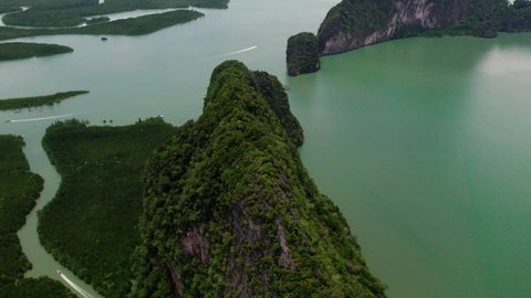Drone diving towards mountain at Phang Nga bay. Boats spotted. Thailand