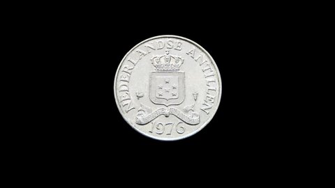 Rotating obverse of Netherlands Antilles coin 25 cents 1976. Isolated in black background.
