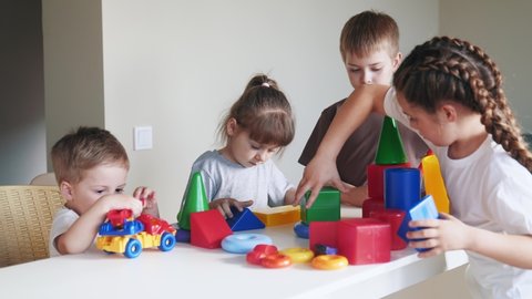 kindergarten. a group of children play toys cubes and cars on the table in kindergarten indoor. kid dream creative happy family preschool education concept. nursery baby toddler home