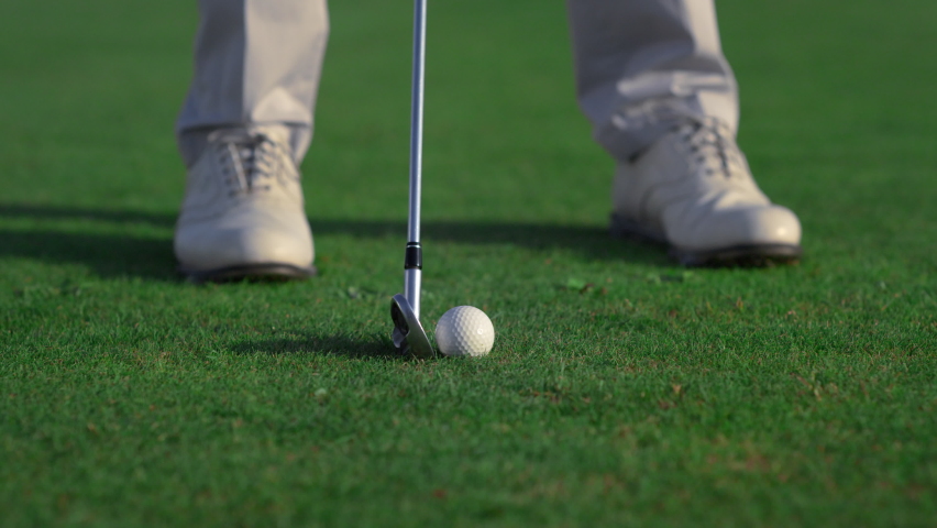 Golfer feet hitting ball on fairway course. Golf man swinging shot on training close up. Unknown golfing club member playing practicing skills on luxury weekend activity. Rich hobby leisure concept. Royalty-Free Stock Footage #1090634049
